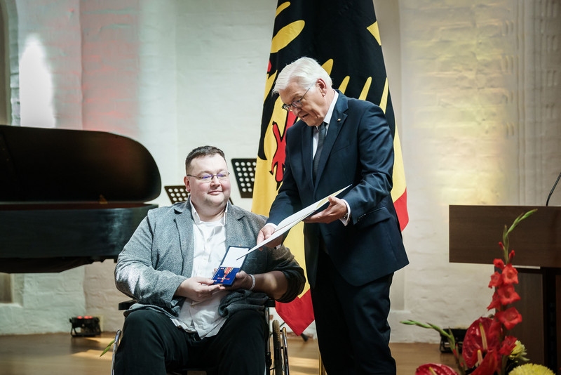 Bundespräsident Frank Walter Steinmeier zeichnet einen Bürger mit dem Bundesverdienstorden aus.