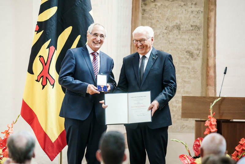 Bundespräsident Frank Walter Steinmeier zeichnet einen Bürger mit dem Bundesverdienstorden aus.